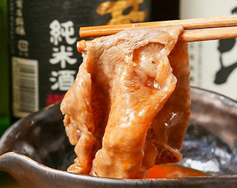 箸で肉を鍋から持ち上げる写真