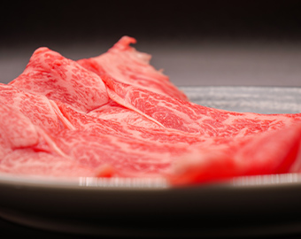 霜降り和牛の薄切り肉が黒い皿に盛られた写真